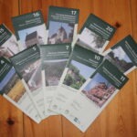 Sammlung von Wander- und Radwanderkarten des Naturparks Neckartal-Odenwald und Geo-Naturparks Bergstraße-Odenwald im Maßstab 1:20.000, nummeriert und mit Landschaftsmotiven.